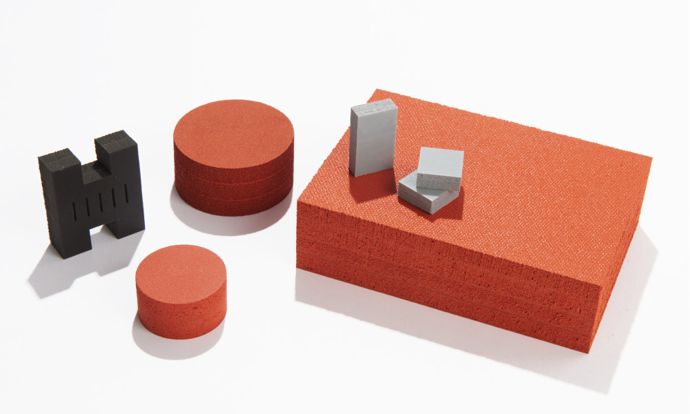 Gray F-12 foam, red sponge pads, and black Poron gasket with layers of material and RTV