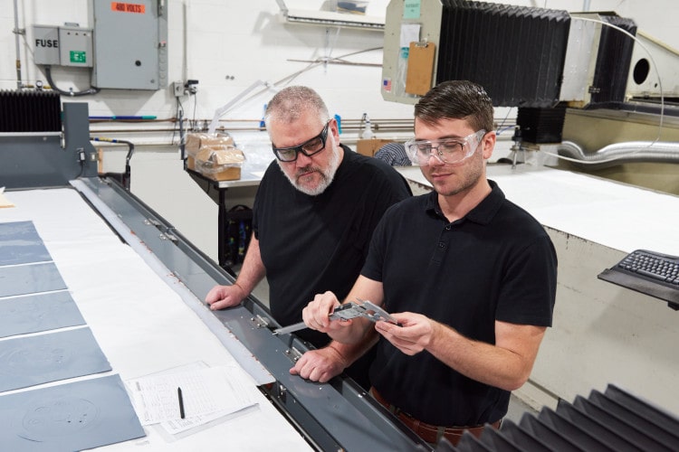 Engineer and operator measuring the size of a part