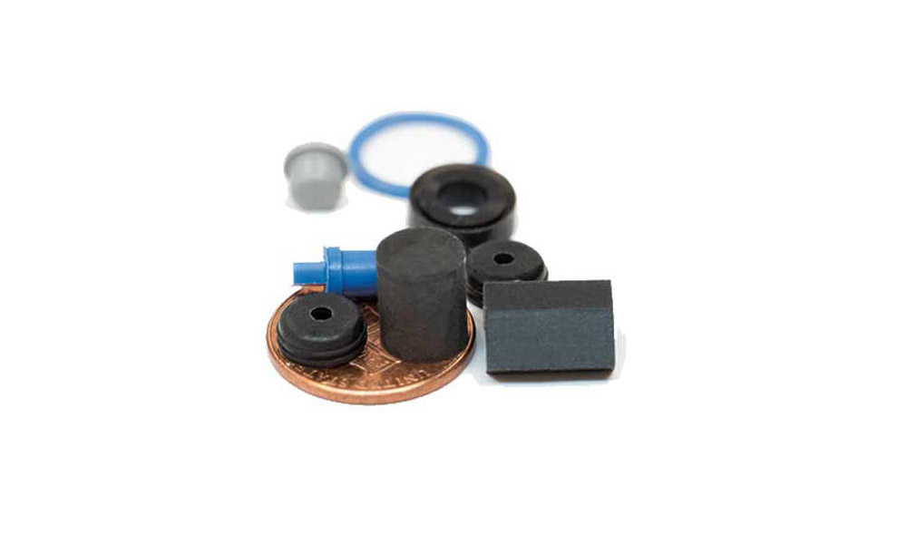 Micro molded parts, positioned by a penny for size comparison