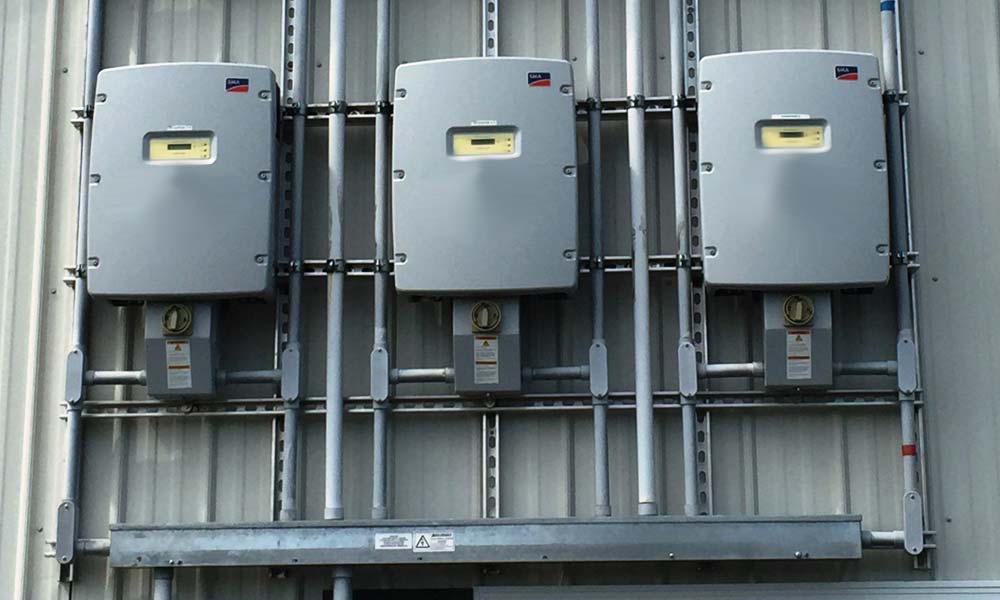 Solar inverter panels shown attached to the side of a building